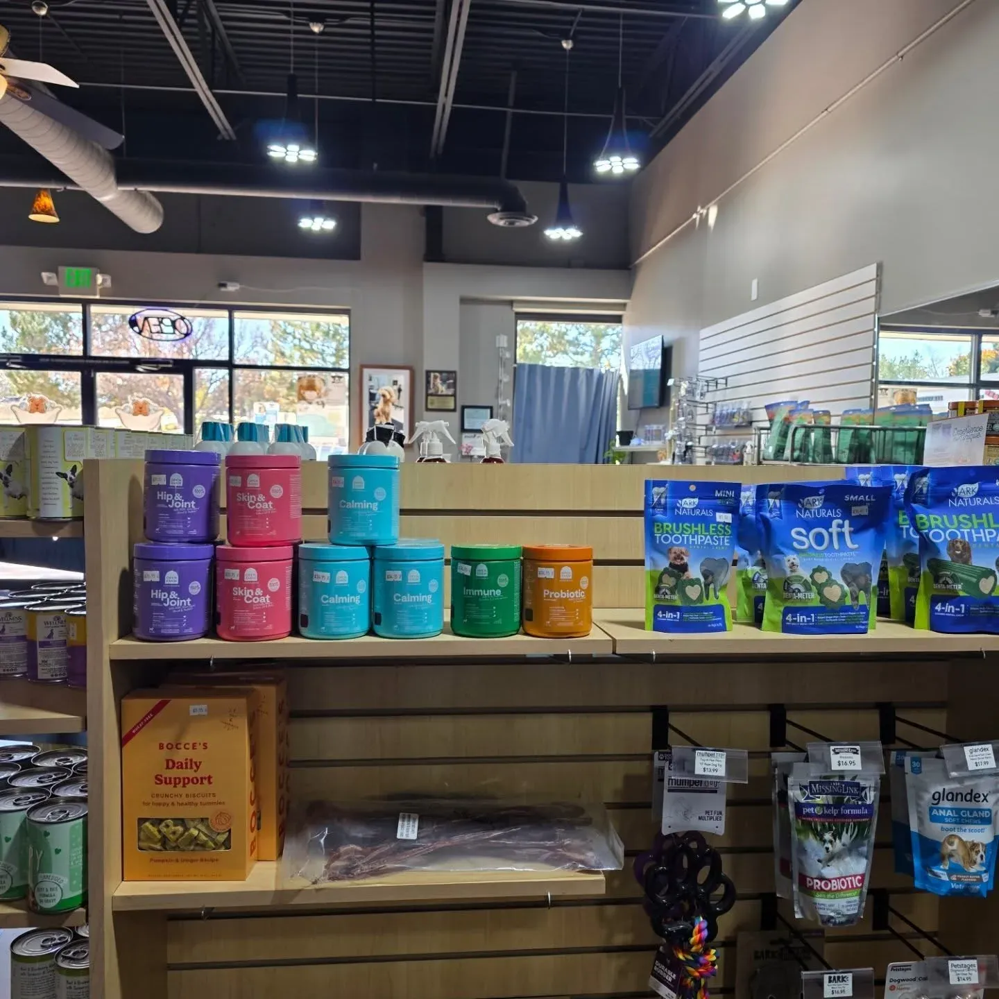 Inside the Barky Mountain Grooming salon in Lone Tree, Colorado: bright shelves of natural pet supplements and treats, with the self-wash area beyond